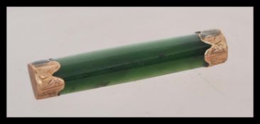 A vintage early 20th century Chinese jade and 9ct gold mounted bar brooch, the ends with