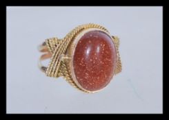 A 14ct gold ring having a large oval goldstone cab