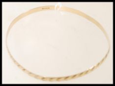 A hallmarked 9ct gold bangle bracelet having an engraved heart design. Weighs 5.1 grams.