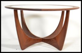 A 1970's G-plan teak model 8040 'Astro' coffee table, with inset circular glass top over stylized