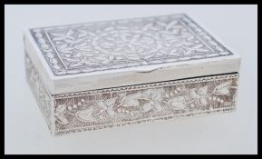 A silver white metal tests as silver decorative snuff box depicting flowers and leaves. The box of