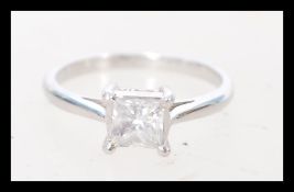 An 18 carat white gold single stone diamond ring having a central square cut diamond of approx 3/4