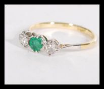 An 18ct gold and platinum set three stone emerald