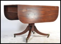A Regency period solid mahogany drop leaf dining t