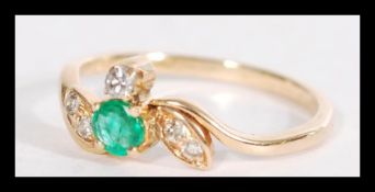 An 18ct yellow gold emerald and diamond ring havin
