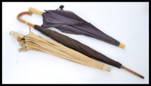 A group of three Edwardian umbrellas one having fa