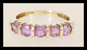 A hallmarked 9ct gold ring having five inset purple qvc gemstones, weighing 2.2 grams hallmarked