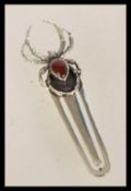 A 20th century silver bookmark with a spider finial having an inlaid red teardrop stone.
