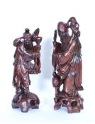 A pair of early 20th century Chinese hardwood figures of elders raised on wooden pedestal base.