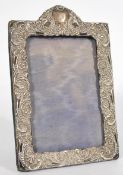 A silver hallmarked easel back picture frame with scrolled flower head design. Measures: 20cm high x