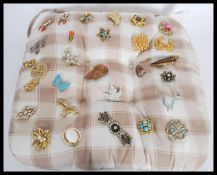 A collection of vintage 20th century ladies brooches to include a yellow metal brooch with inlaid