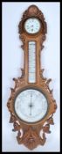 A 20th century Banjo shaped Aneroid oak cased barometer with including a clock face with Roman