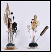A collection of vintage hat pins contained on two circular based hat pin stands. Includes