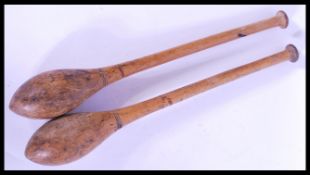 A pair of vintage 20th century turned wooden exercise clubs. measures: 51cm long