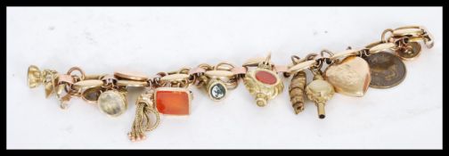 A 9ct gold 20th century charm bracelet with wide links including a heart form locket with floral