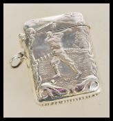A vintage 20th century sterling silver vesta case having an embossed figure of a man playing golf.
