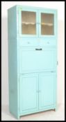 A vintage mid 20th Century upright kitchen unit, an arrangement of glass and panel doors, fall front