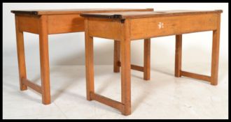 A pair of vintage circa 1950's double beech wood school desks, each fitted with a pair of flip top