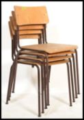 A set of four vintage 20th Century tubular framed village hall stacking chairs, panel seats and back