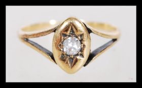 A late 19th century stamped 18ct gold diamond of 10 pts solitaire ring with a split band set into