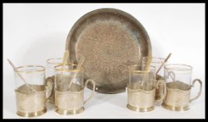 A set of six Persian Islamic tea cups with glass cups having gilt work to the rims and silver