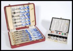 A canteen of Royal Crown Derby cutlery with china handles having blue and white willow patterning in