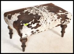 An early 20th Century stool having a recently been upholstered in cow hide. Raised on mahogany