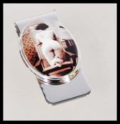 A vintage 20th century silver money clip depicting a sitting nude woman on a chair.