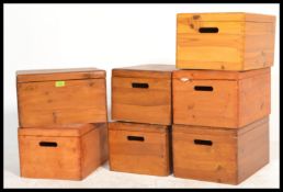 A collection of seven pine lidded storage boxes with carry handles to the side, removable lids.