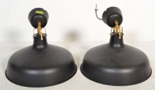 A pair of contemporary retro style ceiling pendant light fixtures, black finish to the outer with