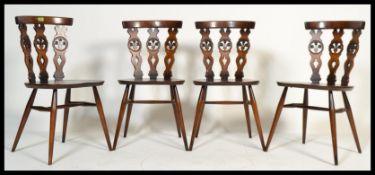 A set of four vintage 20th century Ercol Fleur De Lys dining chairs having a triple splat back fleur
