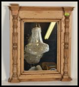 An early 20th century country pine carved mirror having carved columns to the front. Please see
