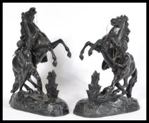 A pair of vintage 20th century spelter figurines of Marley horses and tamers raised on