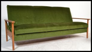 A retro 1960's Danish inspired teak wood day bed sofa. The turned legs supporting a fold down bed