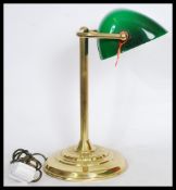 A vintage retro 20th century gilt brass bankers lamp raised on a circular base with reeded column