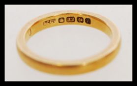 A hallmarked 22ct gold wedding band ring of typical form. Weighs 4.3 grams.