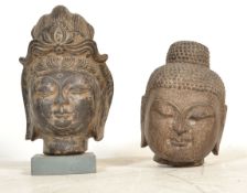 Two 20th Century carved hardstone Buddha heads / Buddhistic icons, one raised on a plinth base.