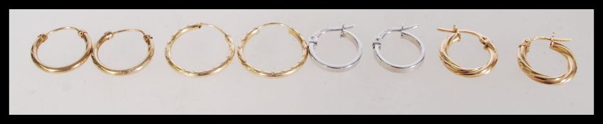 A group of four pairs of 9ct gold sleeper hoop earrings to include a twist design, two pairs of