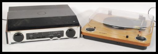 A contemporary record player by ION with built in speakers having a wood finish, together with