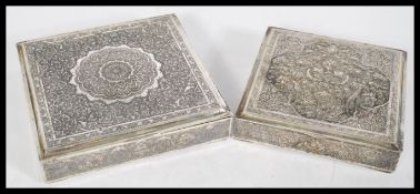 A pair of Persian Islamic silver white metal square trinket boxes with ornate embossed floral
