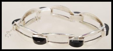 An Art Deco panther link silver bracelet set with black onyx spacers with safety chain. 800 silver