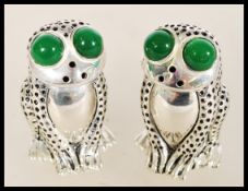 A pair of 20th century 800 silver condiments in the form of frogs having inset green stone eyes