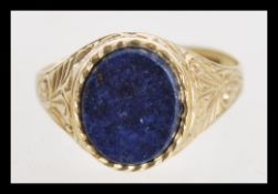 A 9ct gold signet ring with inlaid blue stone and decorative engraving on the shaft. Hallmarked