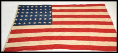 A vintage retro 1940's large American stars and stripes flag having riveted corners. Measures 130 cm