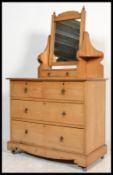 An Edwardian Arts & Crafts pine dressing table raised on a plinth base with short and deep drawers