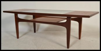 A 1970's retro G-Plan teak wood coffee table of rectangular form raised on tapering legs with