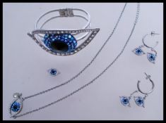 A collection of Grecian inspired jewellery to include an eye design bangle with a hinge opening