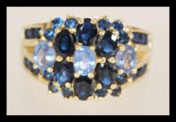 A contemporary Birmingham 9ct gold ladies ring with a split band with inlaid blue stones of two