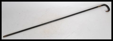 A 19th century Victorian silver collared walking stick cane having a tapering ebonised shaft with