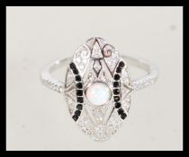 A 20th century art deco style silver ring with an oval head and central inset opal with inset